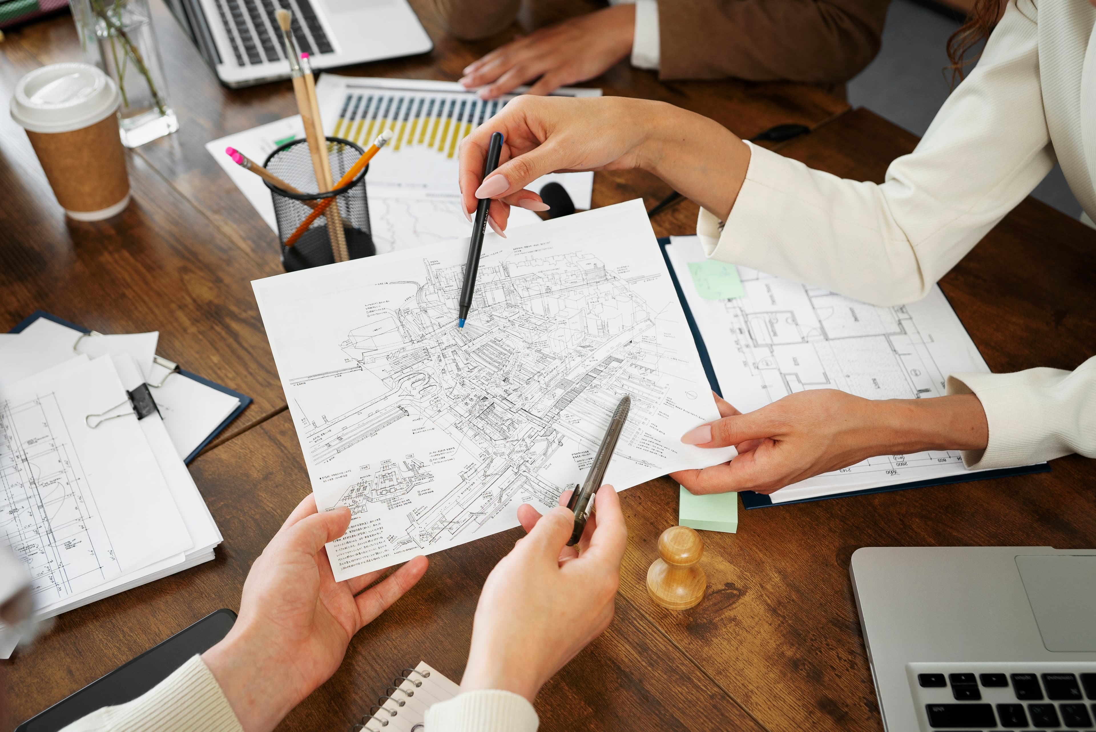 Planners reviewing a site plan drawing at a desk